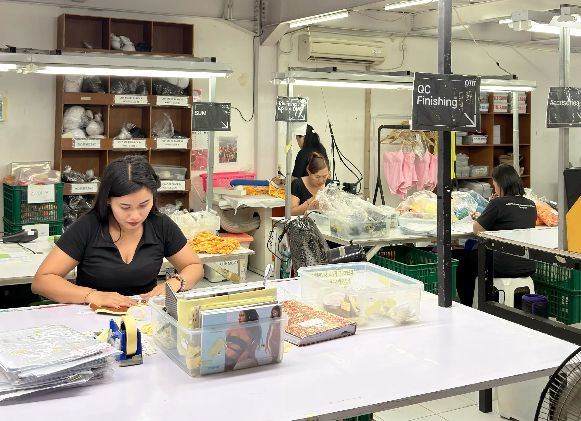 Team members checking and finishing swimwear in the quality control and finishing area