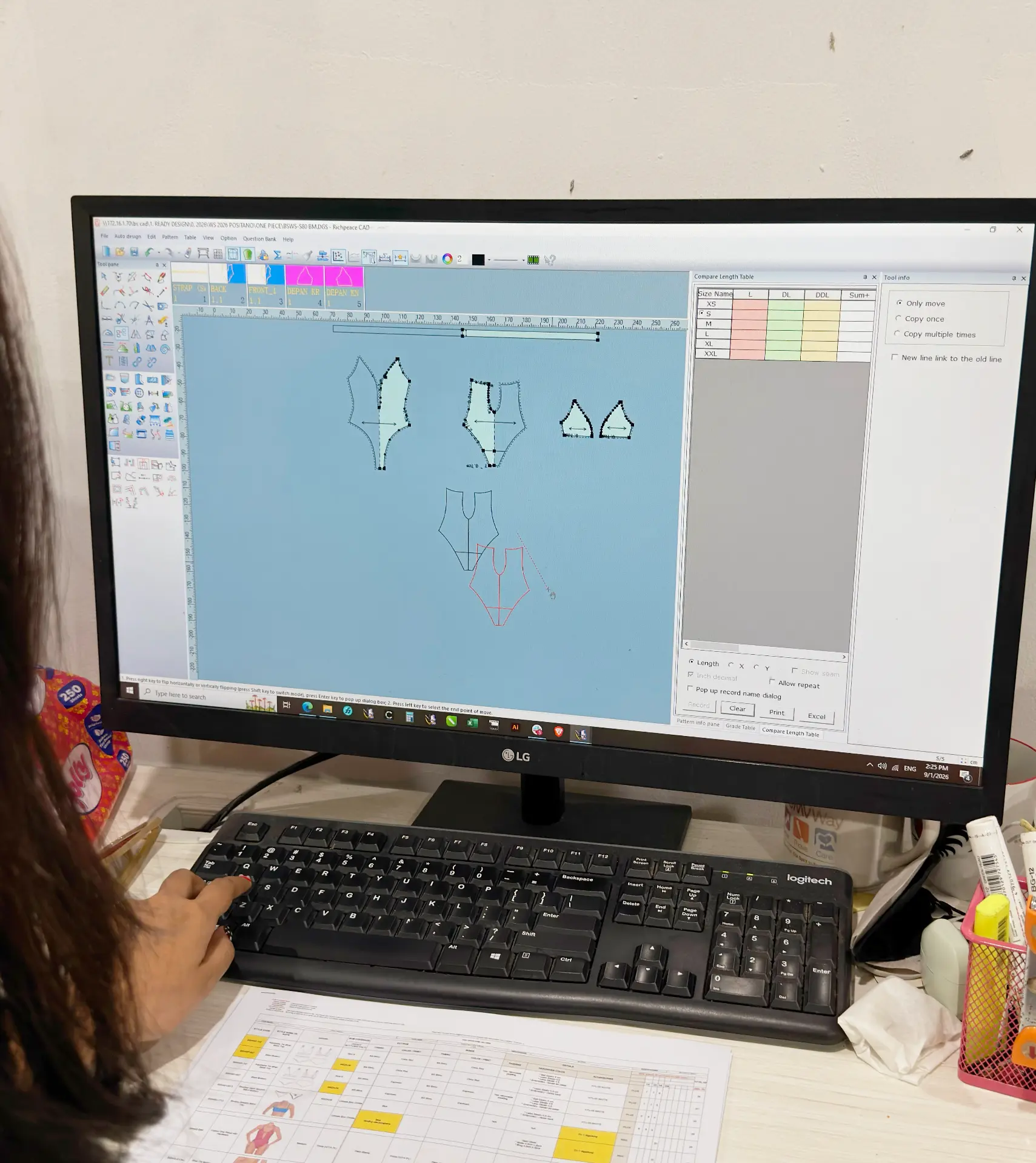 Pattern maker adjusting a swimsuit pattern on screen in the Bali Swim pattern studio